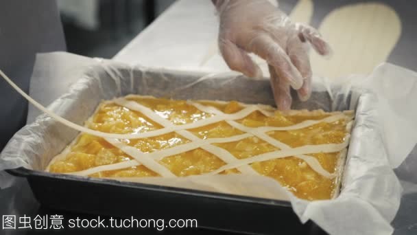 人準(zhǔn)備水果橙色檸檬餡餅在廚房桌上, 最后的裝飾在手套, 餐廳廚房烘焙產(chǎn)品工廠